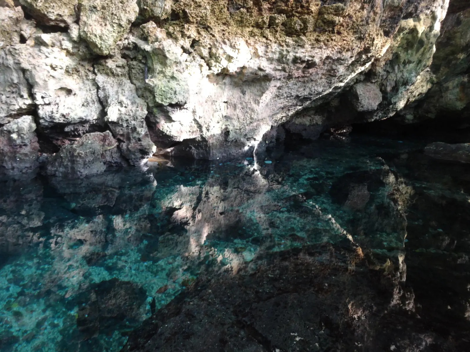 Air jernih berwarna biru kehijauan di antara batuan Goa Air Kontamale di Wanci, Pulau Wangi-Wangi